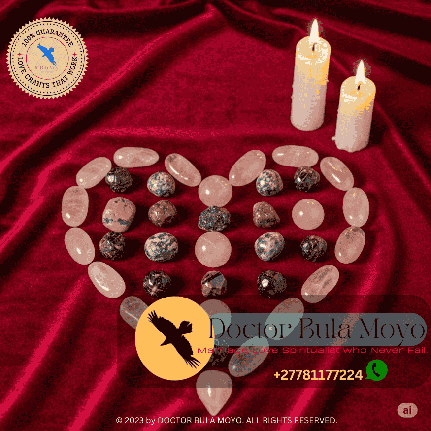 Rose quartz, rhodonite, and garnet crystals arranged in a heart-shaped grid on a velvet cloth with candles nearby.